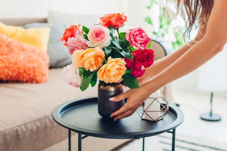 Woman,Puts,Vase,With,Flowers,Roses,On,Table.,Housewife,Taking